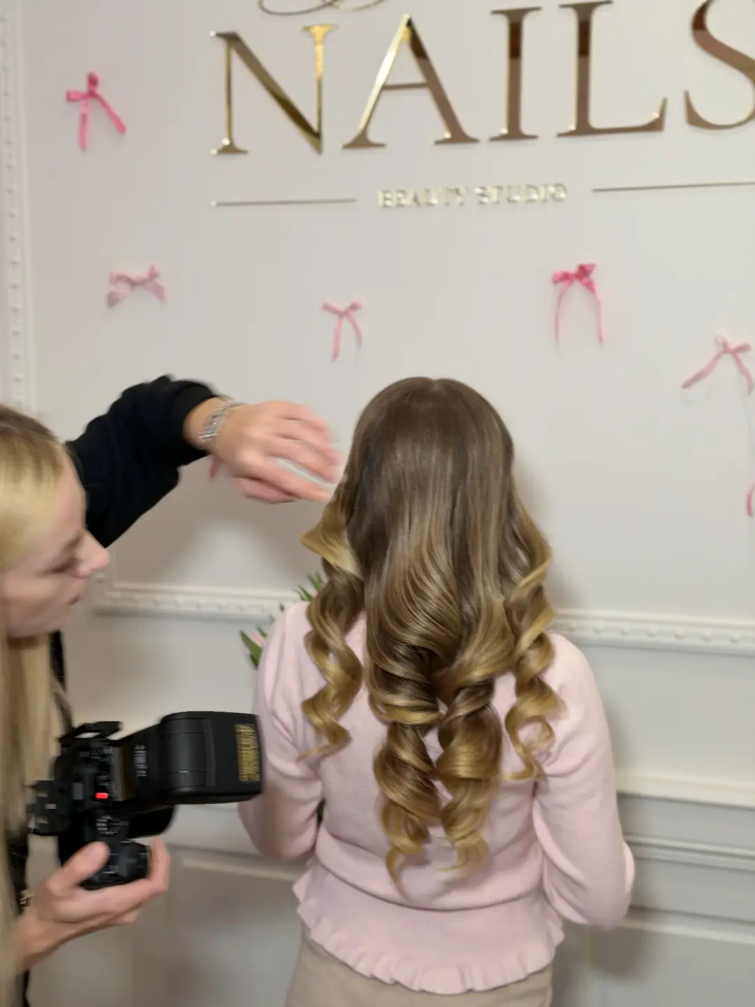 Long blonde spiral curls being finished in a beauty studio