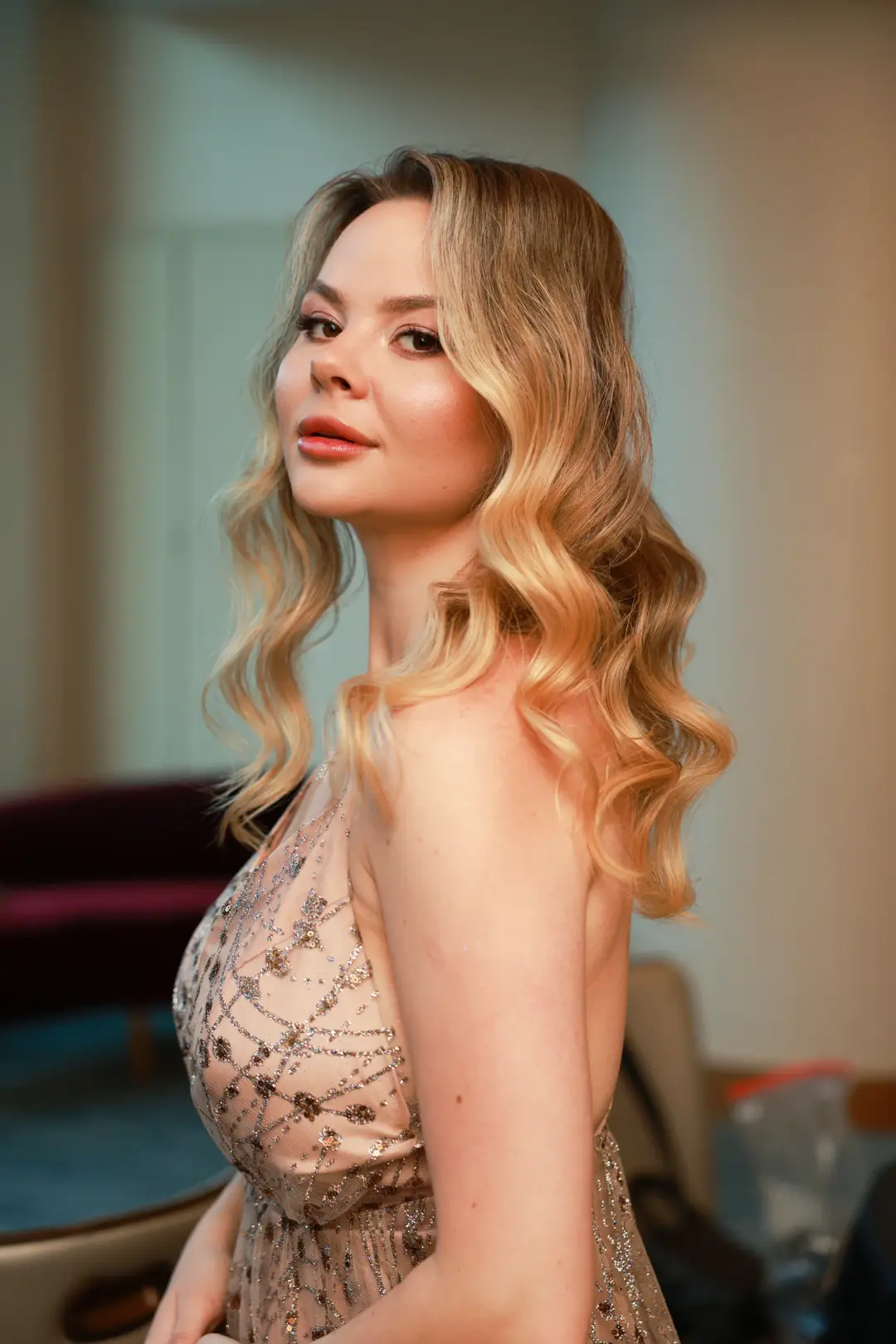 Blonde with shoulder-length soft waves and warm-toned makeup
