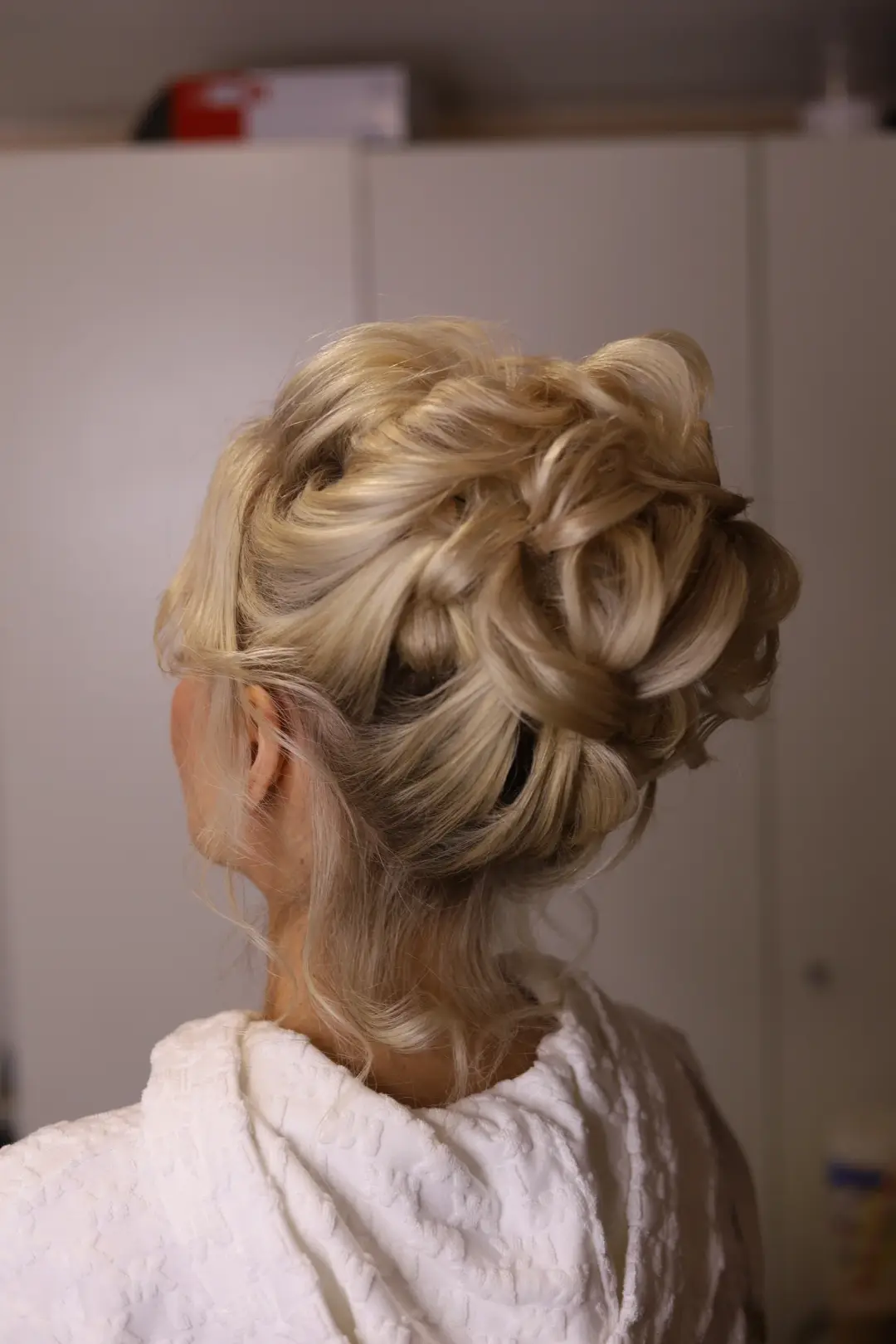 Voluminous blonde updo formed with soft loops and braids